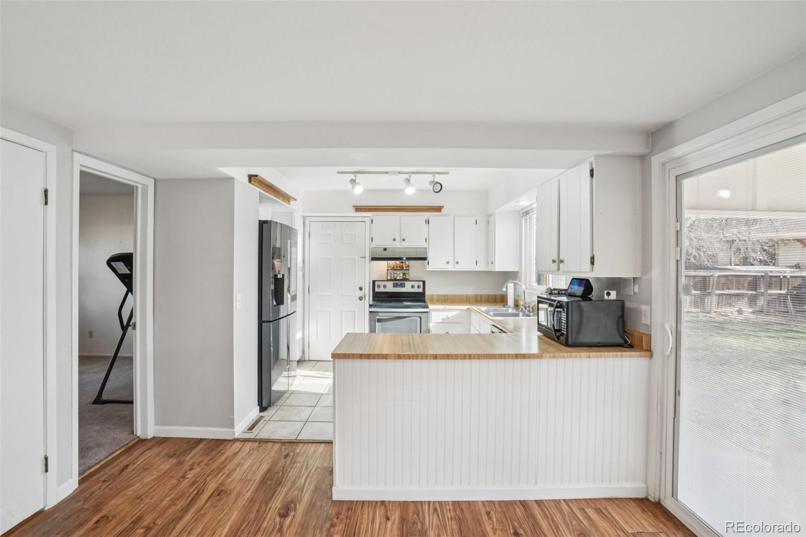 16646 East Rice Circle Aurora, CO 80015 - Photo 12 of 39 a view of a kitchen with a sink dishwasher refrigerator stove and wooden floor