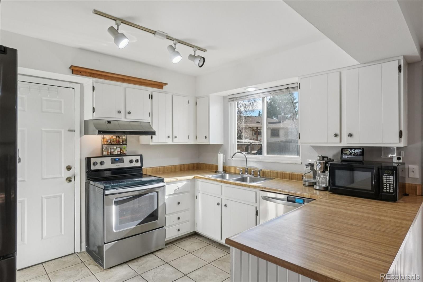 16646 East Rice Circle Aurora, CO 80015 - Photo 13 of 39 a kitchen with a stove a sink and a microwave