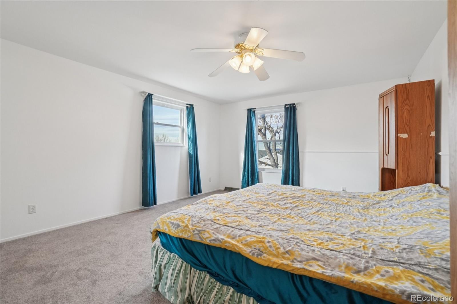 16646 East Rice Circle Aurora, CO 80015 - Photo 19 of 39 a bedroom with a bed and a chandelier