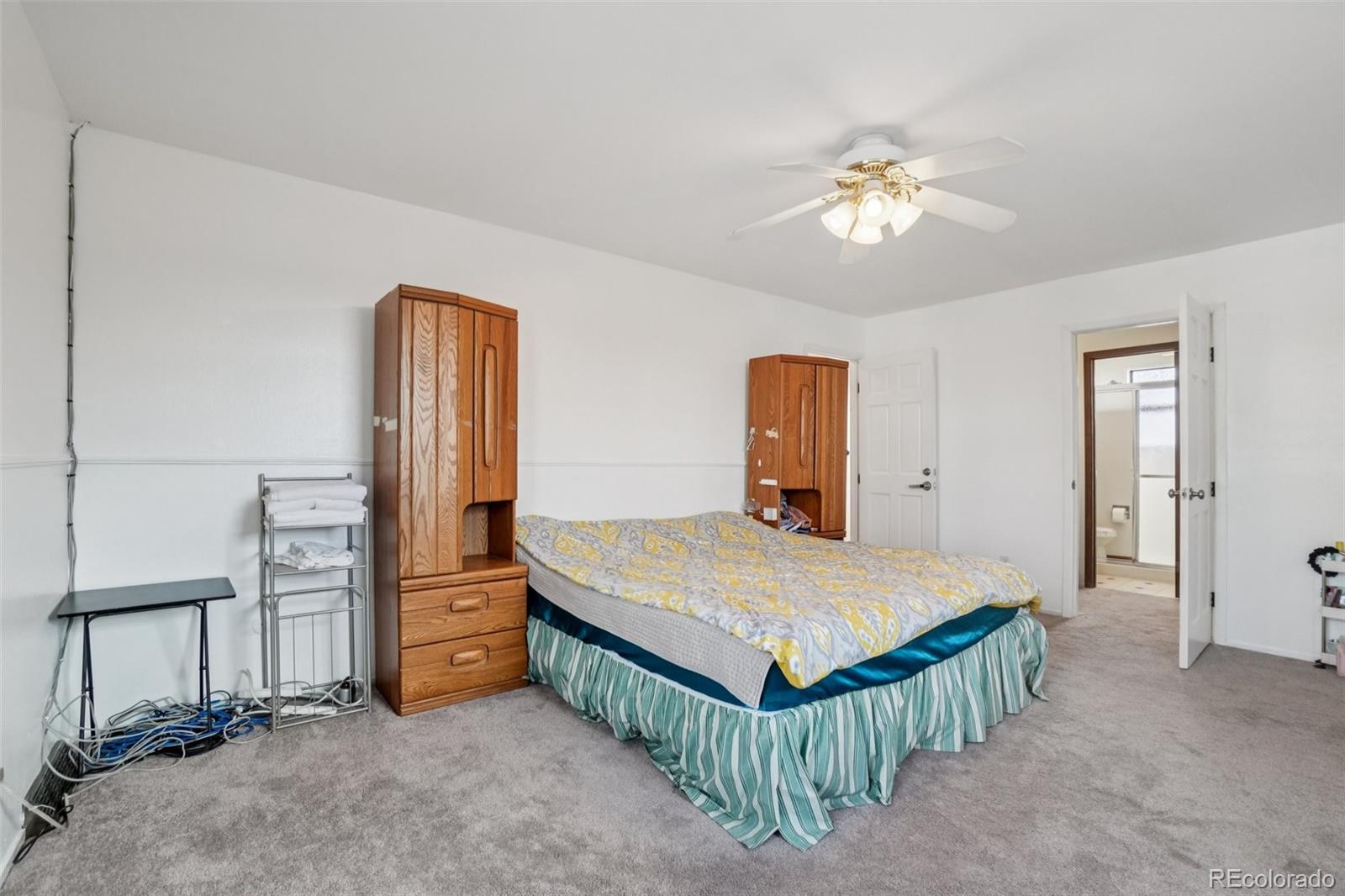 16646 East Rice Circle Aurora, CO 80015 - Photo 21 of 39 a bedroom with a bed and a chandelier