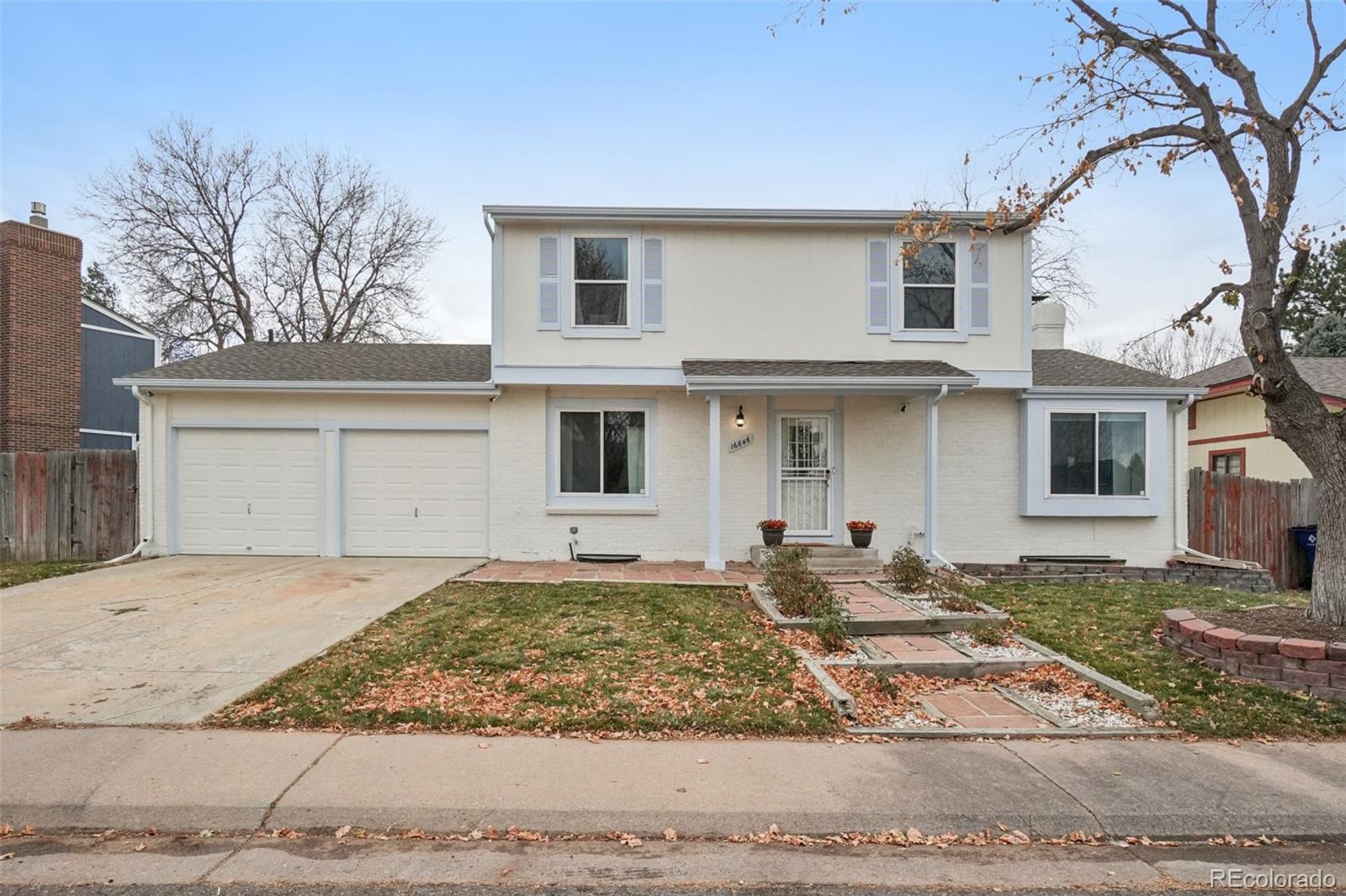 16646 East Rice Circle Aurora, CO 80015 - Photo 3 of 39 a front view of a house with garden