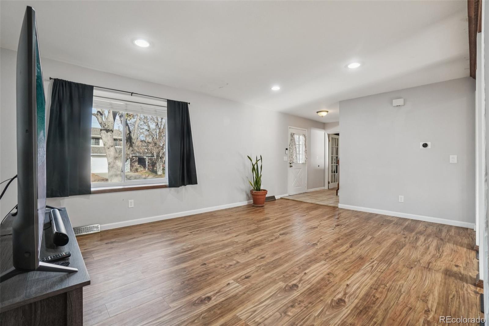 16646 East Rice Circle Aurora, CO 80015 - Photo 7 of 39 a view of an empty room with window and wooden floor