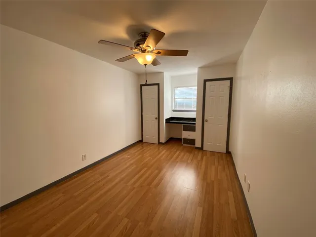 a view of a livingroom with wooden floor and a ceiling fan