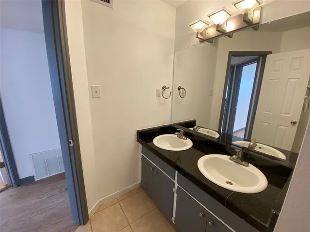 a bathroom with a sink vanity granite and a mirror