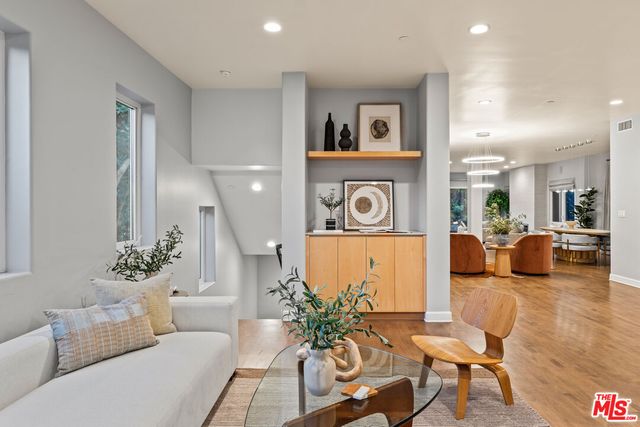a living room with furniture flowerpot and a chandelier