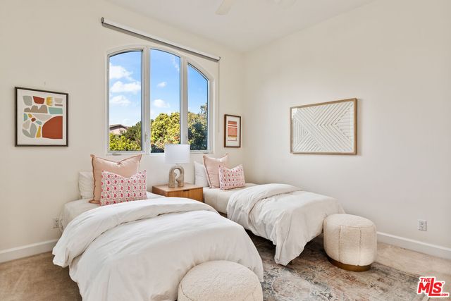 a bedroom with two beds and painting on the wall