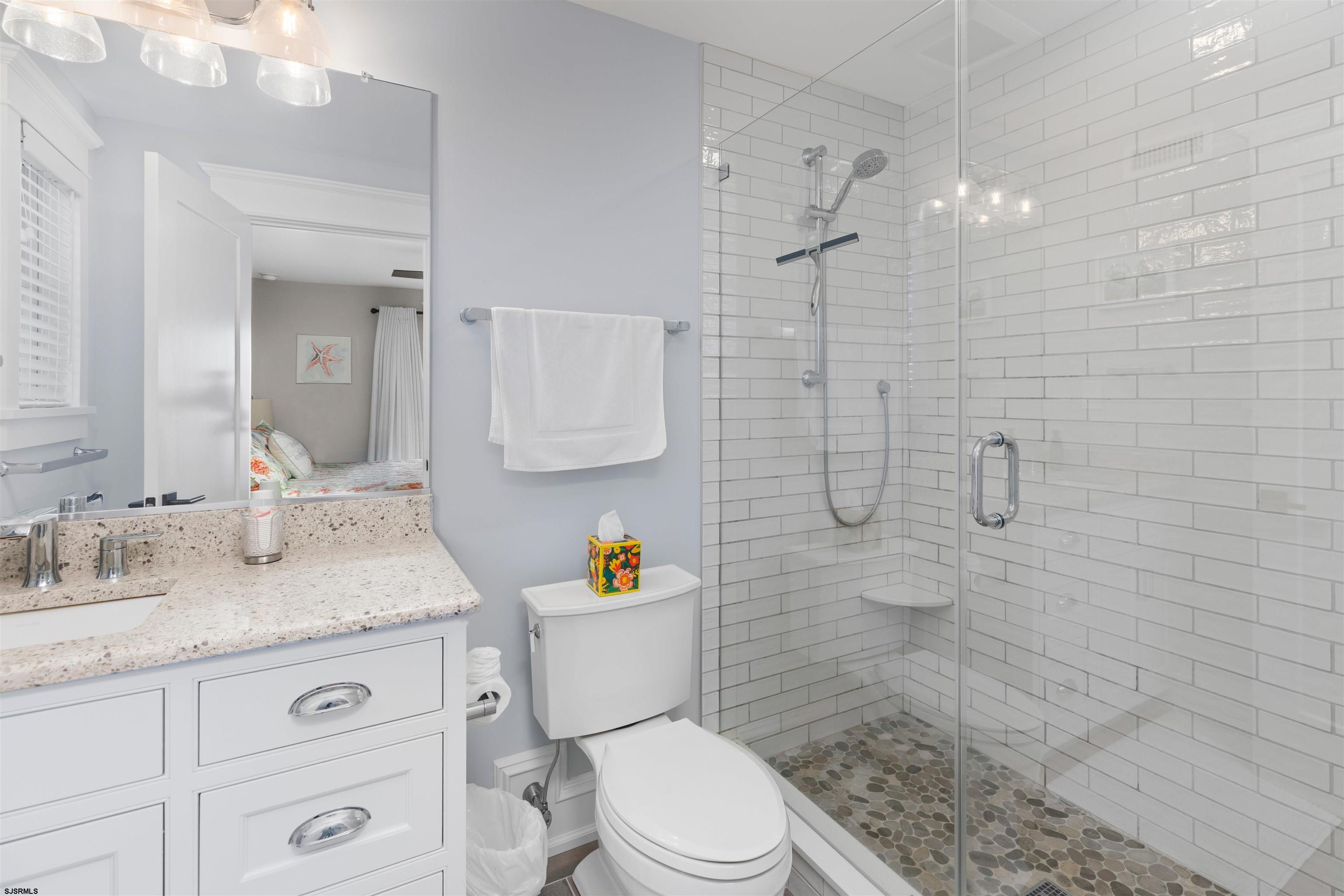 3913 Central Avenue, Unit A Ocean City, NJ 08226 - Photo 15 of 31 a bathroom with a granite countertop sink a toilet a mirror and shower