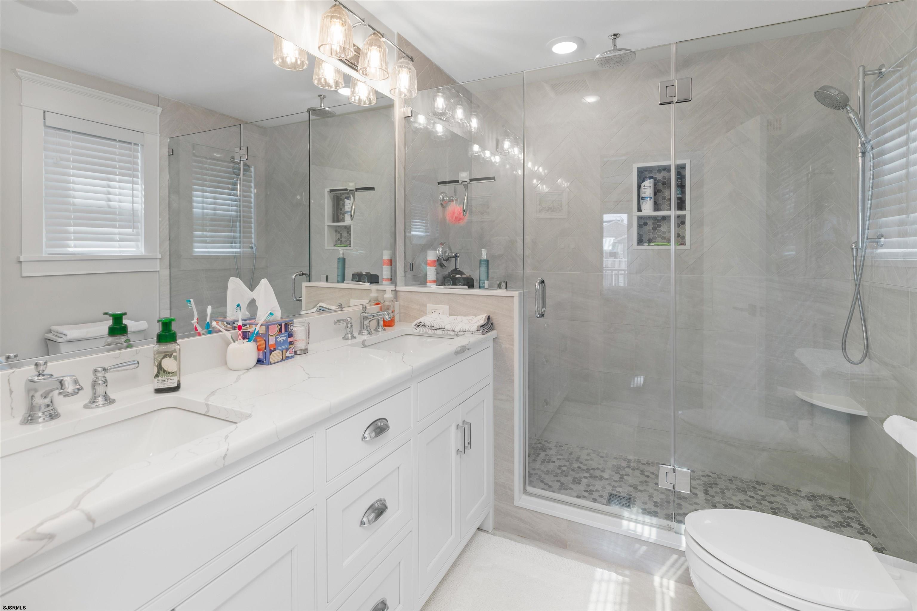 3913 Central Avenue, Unit A Ocean City, NJ 08226 - Photo 18 of 31 a bathroom with a double vanity sink mirror double shower and a toilet
