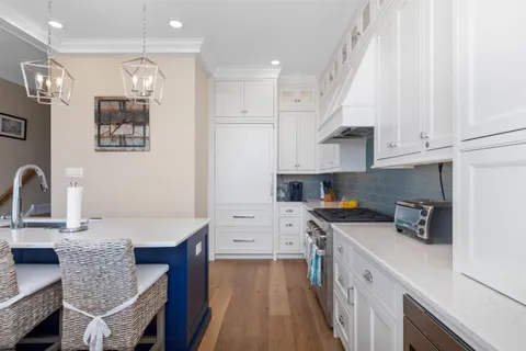 a large kitchen with stainless steel appliances granite countertop a lot of counter space and wooden floor
