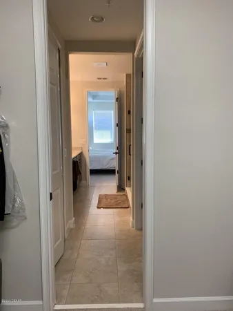 a view of a hallway with a livingroom and a bathroom