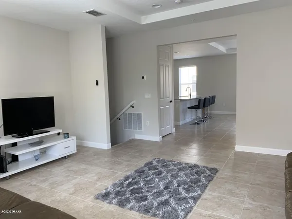 a view of a livingroom with wooden floor and a flat screen tv