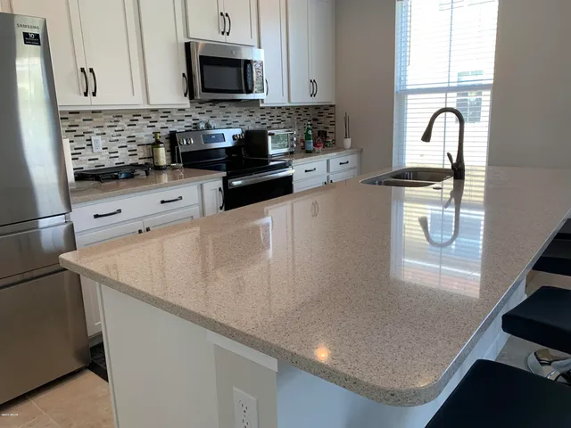 a kitchen with stainless steel appliances granite countertop a sink a stove and a microwave