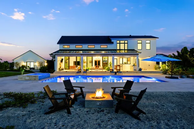 a view of a house with swimming pool and sitting area