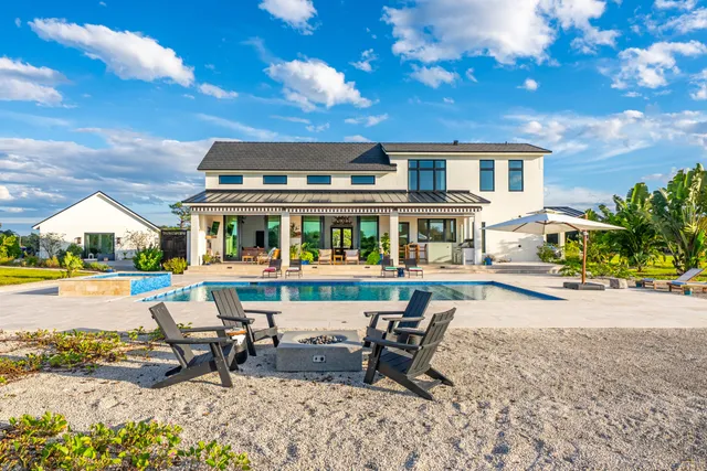 a living room with furniture fireplace and large windows