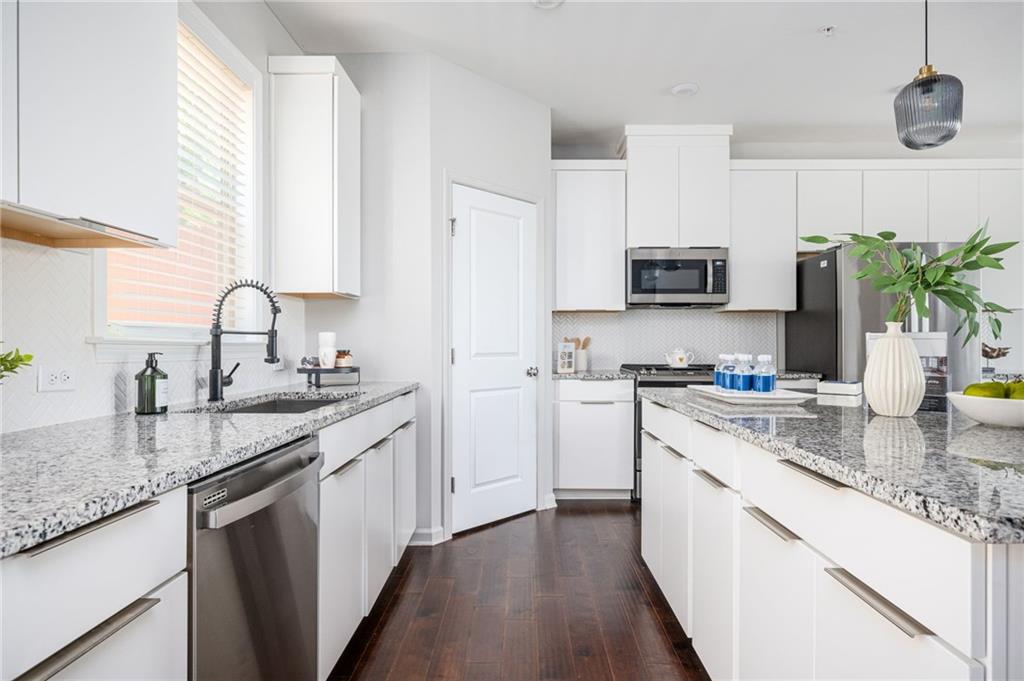 1444 Ridgebend Way Southeast Mableton, GA 30126 - Photo 17 of 34 a kitchen with stainless steel appliances granite countertop a sink stove and refrigerator