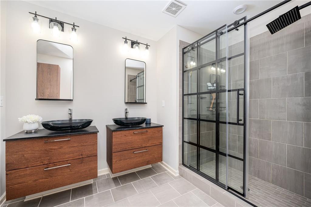 1444 Ridgebend Way Southeast Mableton, GA 30126 - Photo 24 of 34 a bathroom with a granite countertop sink a mirror and shower