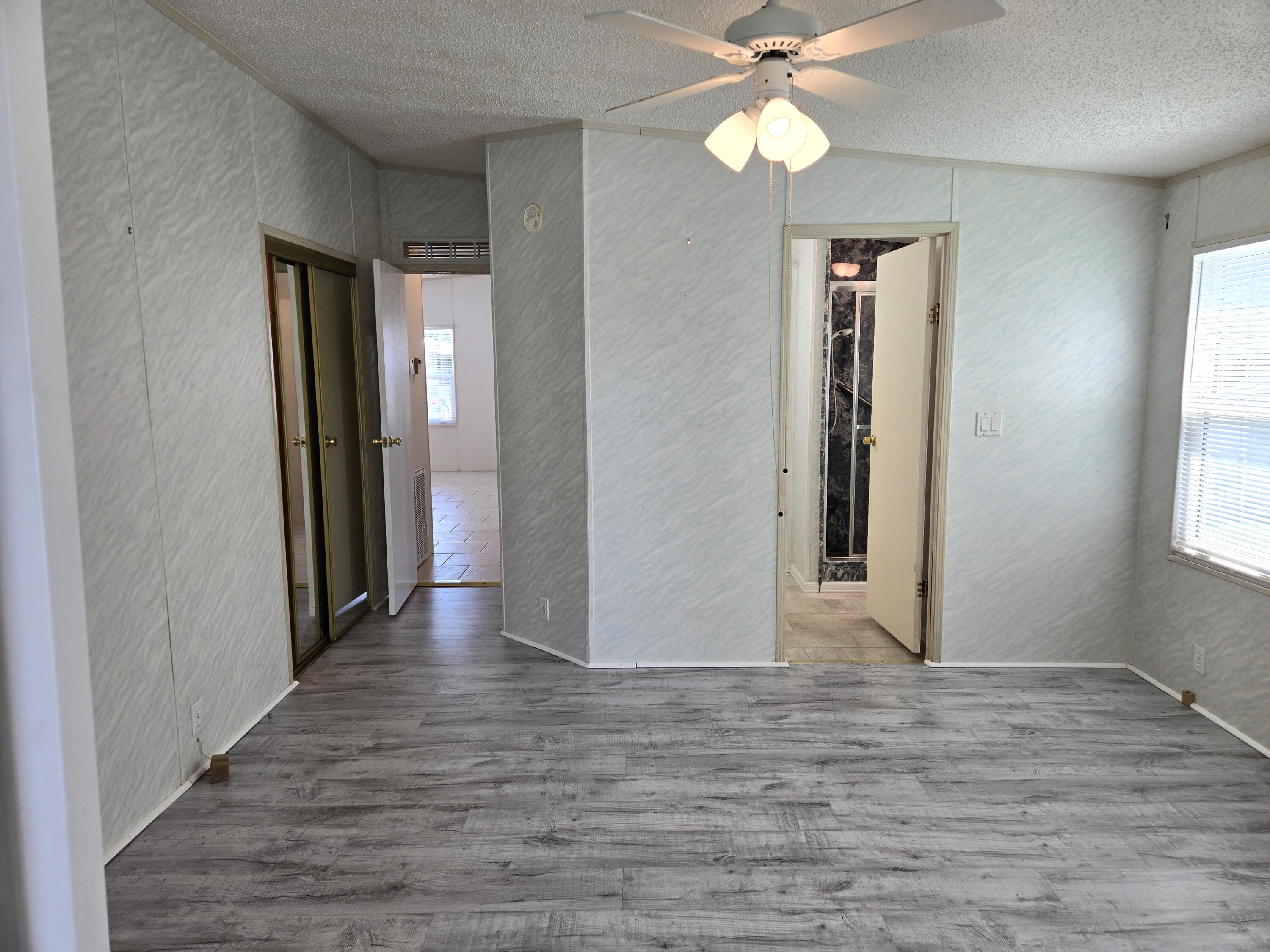 1586 Southwest 35th Circle Okeechobee, FL 34974 - Photo 18 of 37 a view of a hallway with wooden floor and a chandelier fan