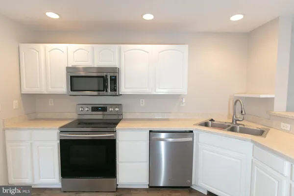 a kitchen with a sink stove and microwave
