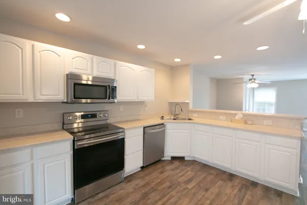 a large kitchen with stainless steel appliances lots of counter space sink and cabinets