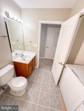 a bathroom with a sink a toilet a mirror and vanity