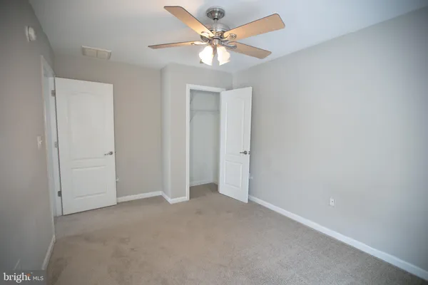 an empty room with a chandelier fan and a chandelier fan