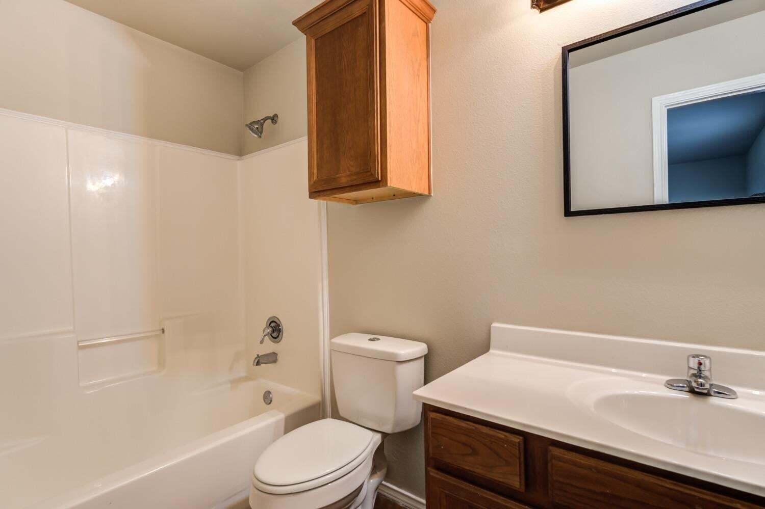 6554 92nd Street Lubbock, TX 79424 - Photo 11 of 17 a bathroom with a sink a toilet and shower