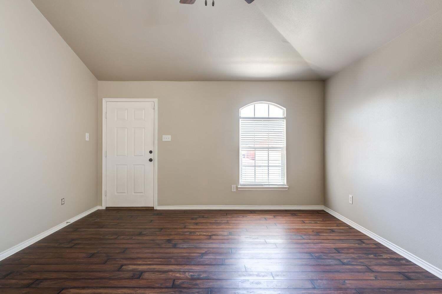 6554 92nd Street Lubbock, TX 79424 - Photo 3 of 17 an empty room with wooden floor and window