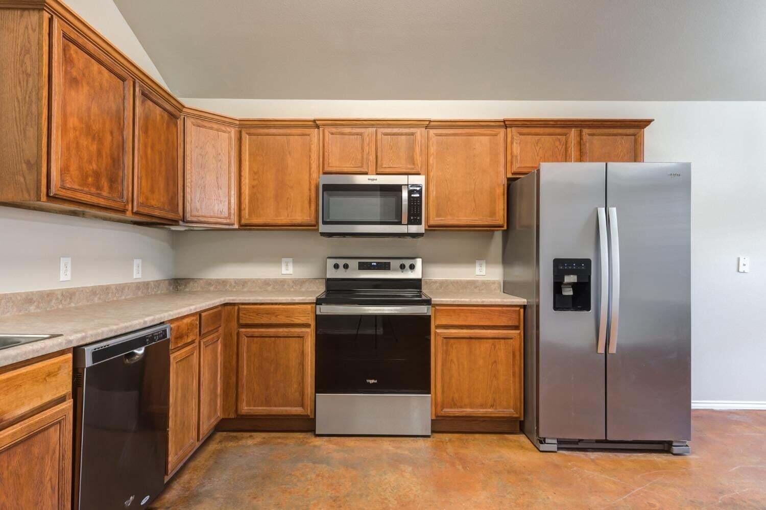 6554 92nd Street Lubbock, TX 79424 - Photo 6 of 17 a kitchen with stainless steel appliances granite countertop a refrigerator and a stove top oven