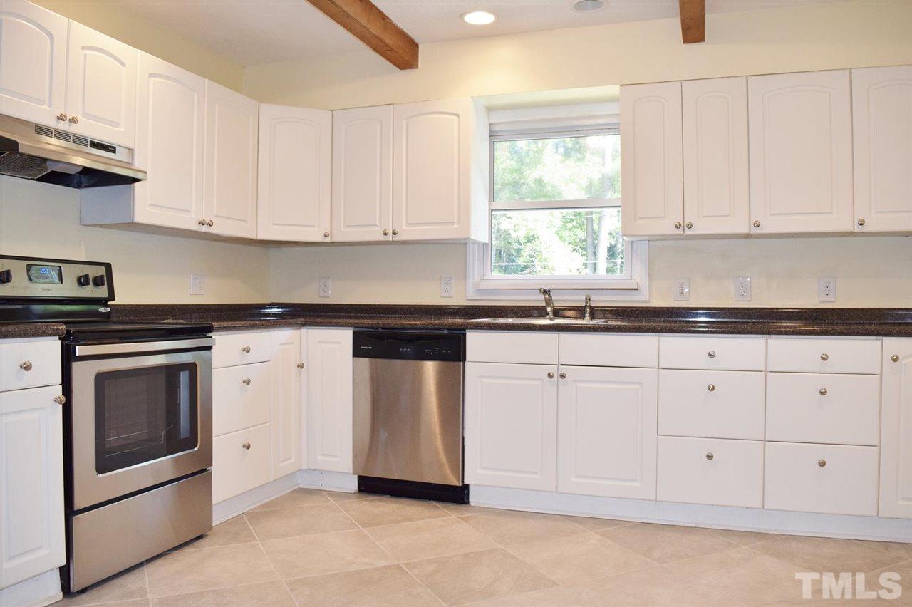 3606 Woodside Road Garner, NC 27529 - Photo 2 of 16 a kitchen with granite countertop white cabinets and white appliances