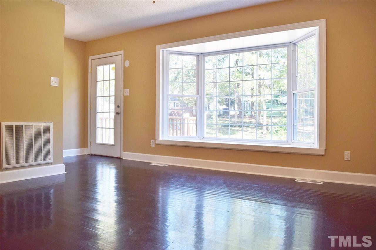 3606 Woodside Road Garner, NC 27529 - Photo 4 of 16 a view of an empty room with wooden floor and a window