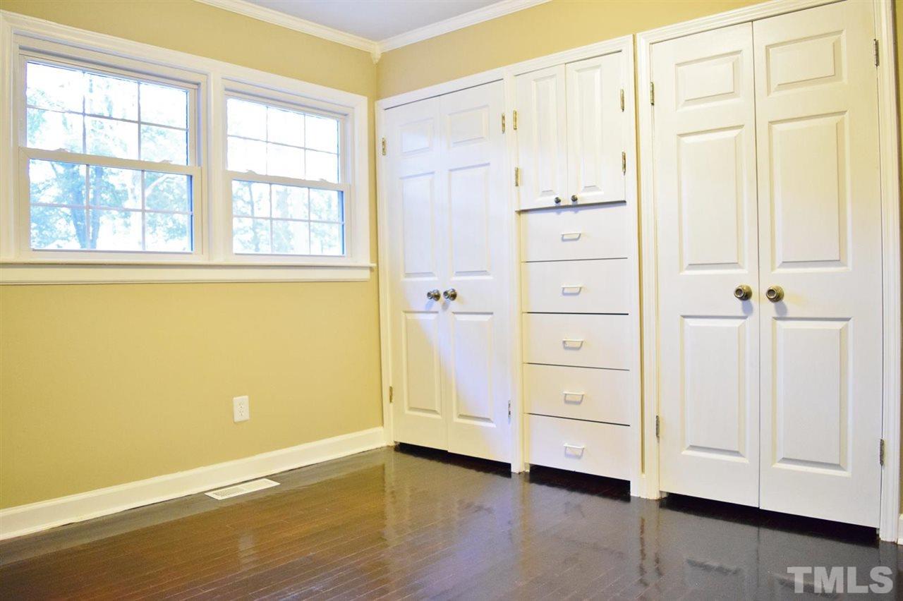 3606 Woodside Road Garner, NC 27529 - Photo 6 of 16 an empty room with a wooden cabinet and mirror