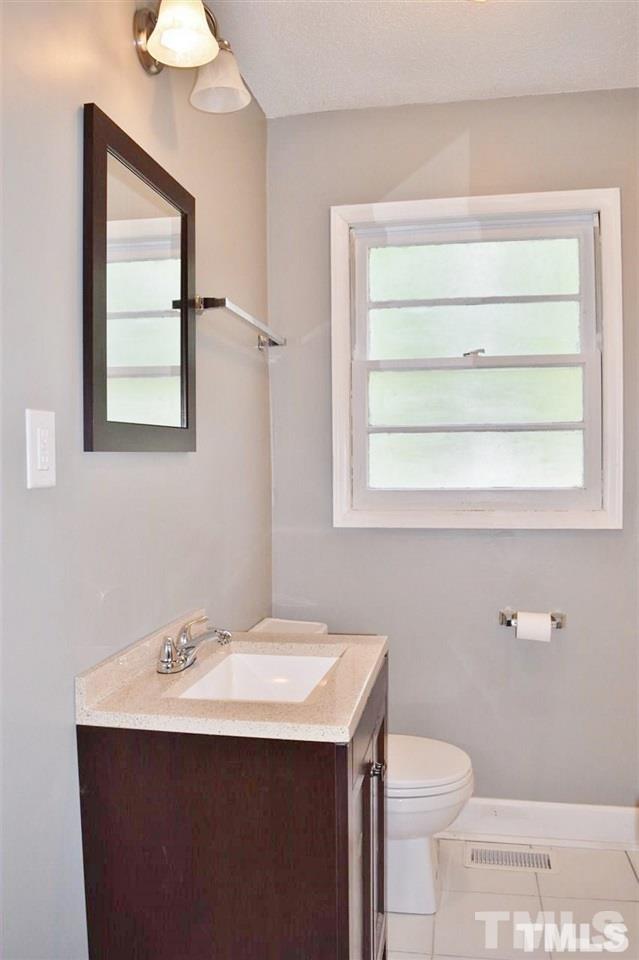 3606 Woodside Road Garner, NC 27529 - Photo 7 of 16 a bathroom with a sink toilet and mirror