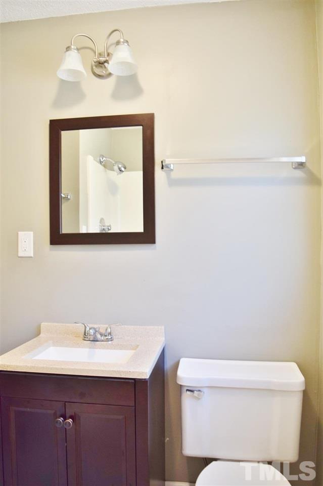 3606 Woodside Road Garner, NC 27529 - Photo 8 of 16 a bathroom with a toilet sink and mirror