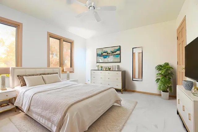 a spacious bedroom with a large bed and a potted plant