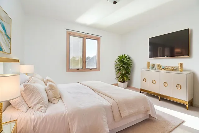 a bedroom with a bed and a flat screen tv