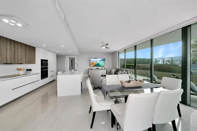 a view of a swimming pool with a lawn chairs and a palm tree