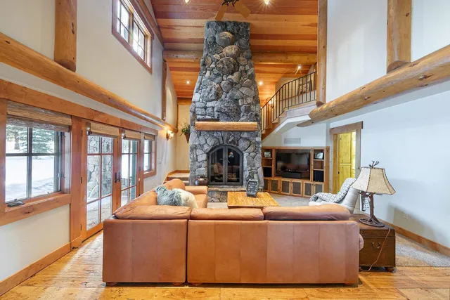 a living room with fireplace furniture and a large window