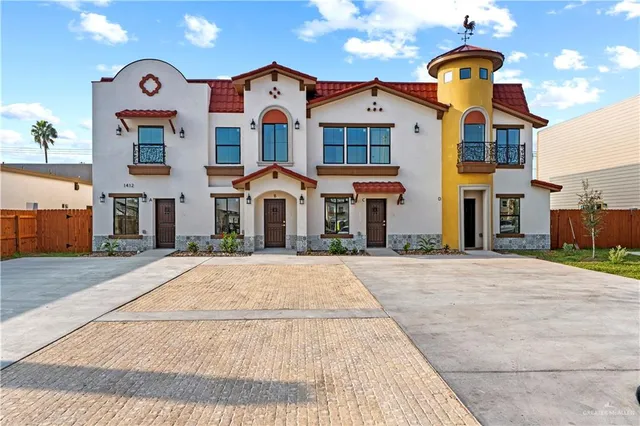 front view of a brick house with a yard