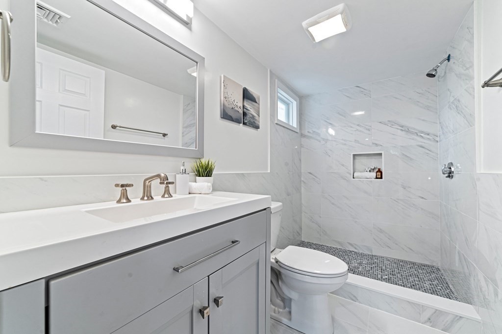 40 Howe Street Quincy, MA 02169 - Photo 26 of 42 a bathroom with a sink a toilet a mirror and shower