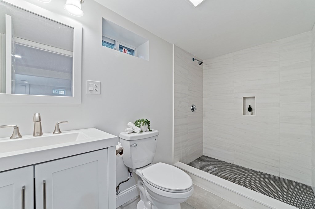40 Howe Street Quincy, MA 02169 - Photo 40 of 42 a bathroom with a toilet sink vanity and mirror