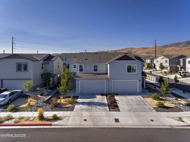 an aerial view of residential houses with outdoor space and parking