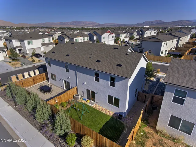 an aerial view of a city with lots of residential buildings and mountain view in back