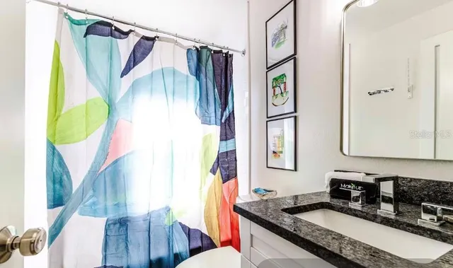 a bathroom with a granite countertop sink and a mirror