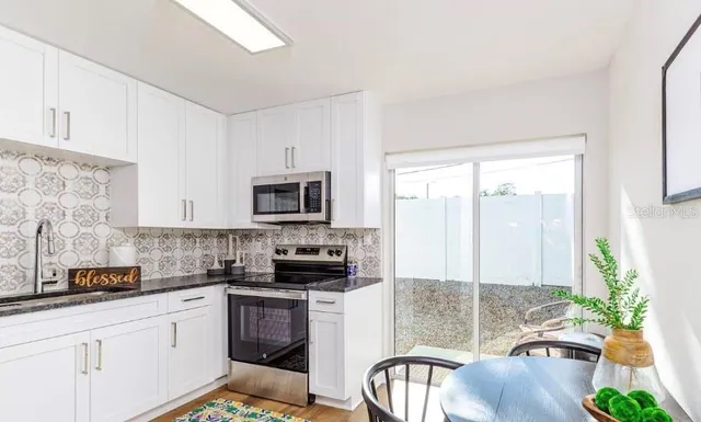 a kitchen with stainless steel appliances a stove a sink a microwave a refrigerator and cabinets