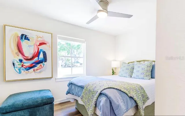 a bedroom with a bed and a painting on the wall