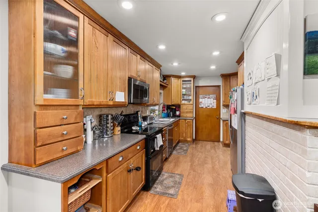 a kitchen with stainless steel appliances kitchen island granite countertop a stove a sink and a refrigerator