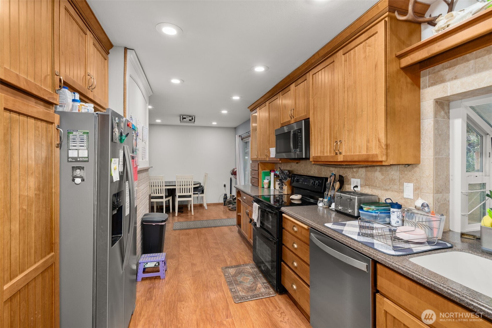 137 Aldrich Road Mossyrock, WA 98564 - Photo 12 of 30 a kitchen with stainless steel appliances granite countertop a refrigerator a sink dishwasher a stove and a dining table with wooden floor