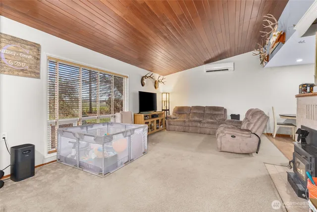 a living room with furniture flat screen tv and a large window