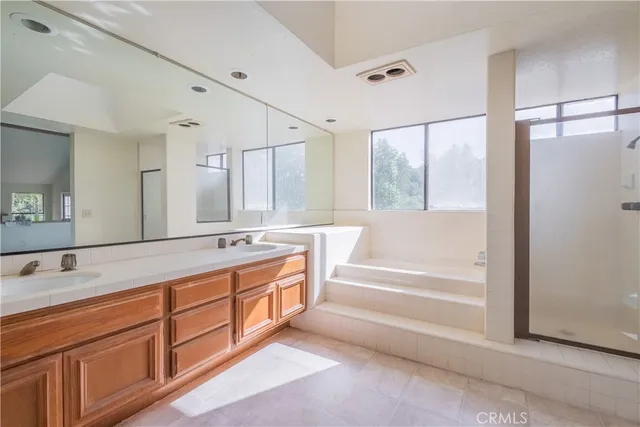 a spacious bathroom with a tub sink and mirror