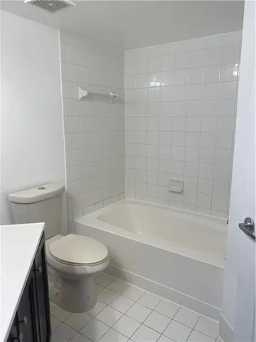 a white toilet and tub sitting next to a bathroom sink